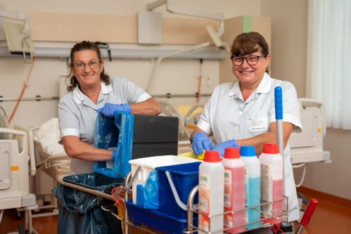 Zwei Reinigungskräfte des Kepler Universitätsklinikum beim Reinigen eines Patientenzimmers.